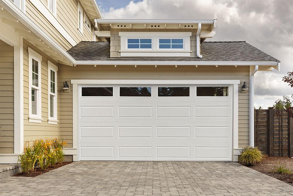 Modern house with white garage door and paved driveway